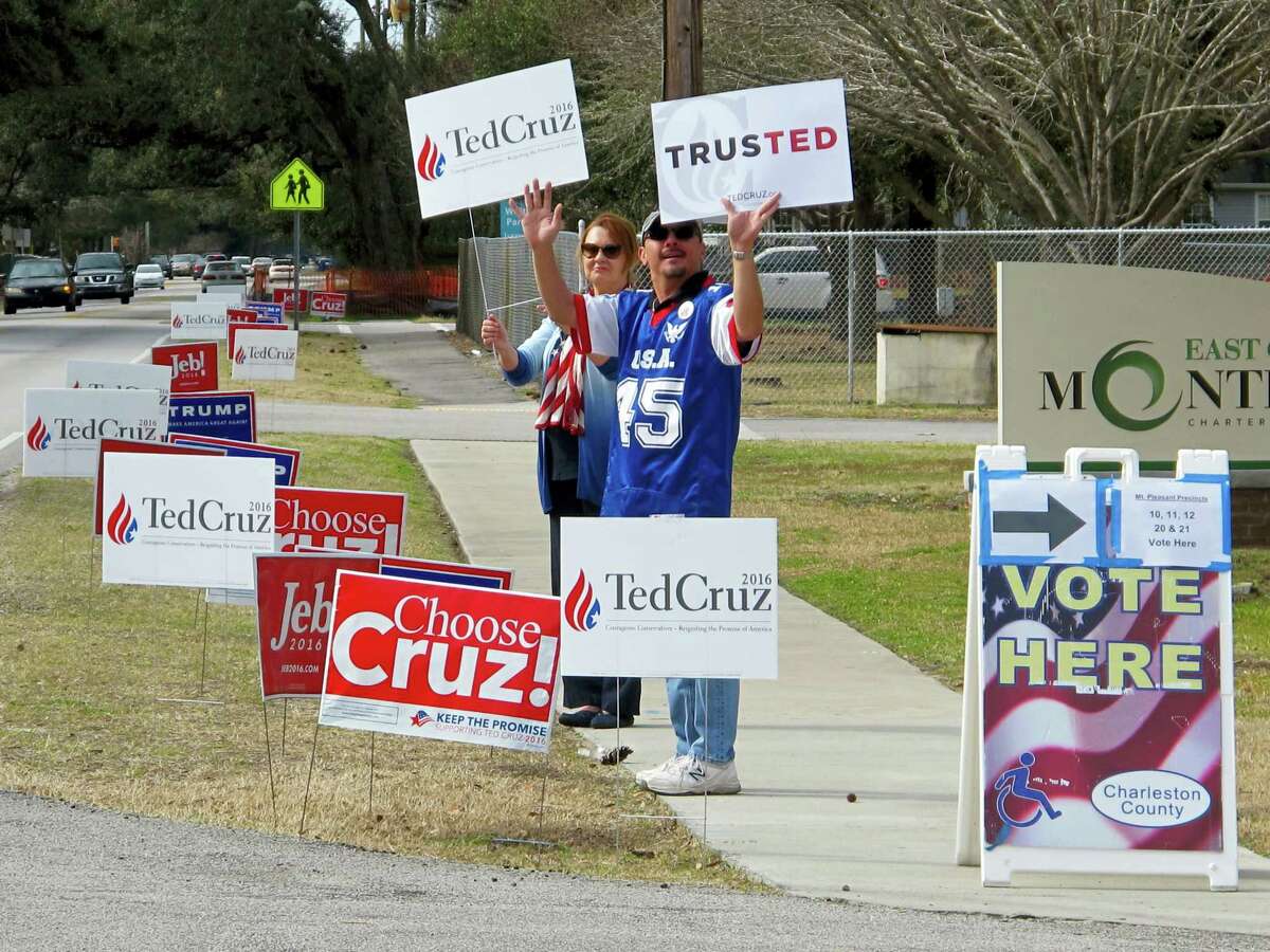 Supporters of Texas Sen. Ted Cruz hold campaign signs outside a polling place in Mount Pleasant, S.C., during the GOP presidential primary in South Carolina on Feb. 20, 2016.