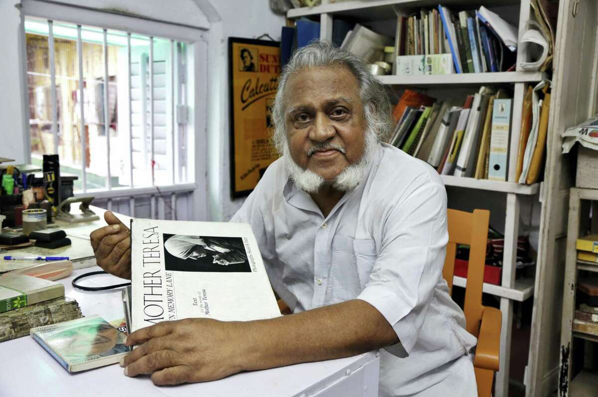 In this Aug. 29, 2016, photo, freelance photographer Sunil K. Dutt displays his book on Mother Teresa in Kolkata, India. Dutt began covering Mother Teresa’s work in Kolkata in 1965 and has one of the largest collections of photographs of the nun. “From the day I first met her Mother always appeared to me a living saint in action,” the 80-year-old said. “My association with Mother Teresa has impacted my life in a very big way. Whenever I think of her I feel a profound peace in the very core of my heart.”