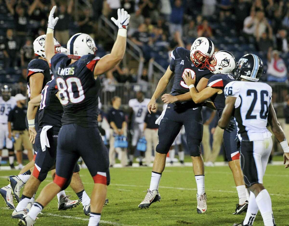 UConn’s Bobby Puyol, second from right, embraces teammate Tyler Davis (9) after making a field goal to give UConn a 24-21 lead over Maine late in Thursday’s game.
