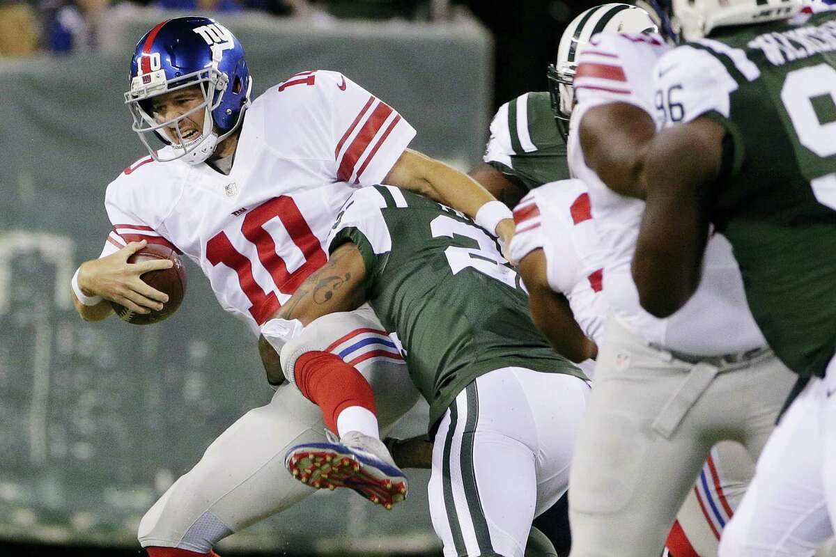 Giants quarterback Eli Manning is sacked during Saturday’s game against the Jets.
