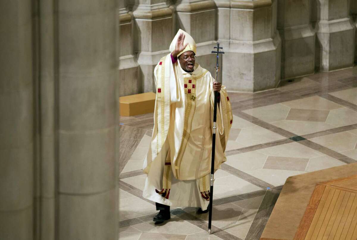 In this Nov. 1, 2015 photo, Episcopal Church Presiding Bishop Michael Curry waves to the crowd after Mass at the Washington National Cathedral in Washington. Curry, the church’s first black leader, was elected in June 2015 to succeed Presiding Bishop Katharine Jefferts Schori, the first woman leader of the church.