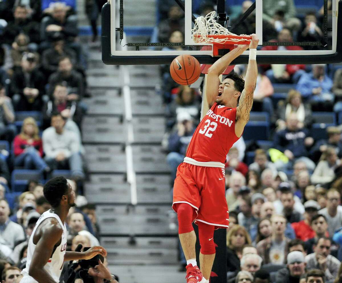 Houston’s Rob Gray reacts while dunking the ball as UConn’s Kentan Facey looks on, in the first half of the Huskies’ loss to the Cougars.