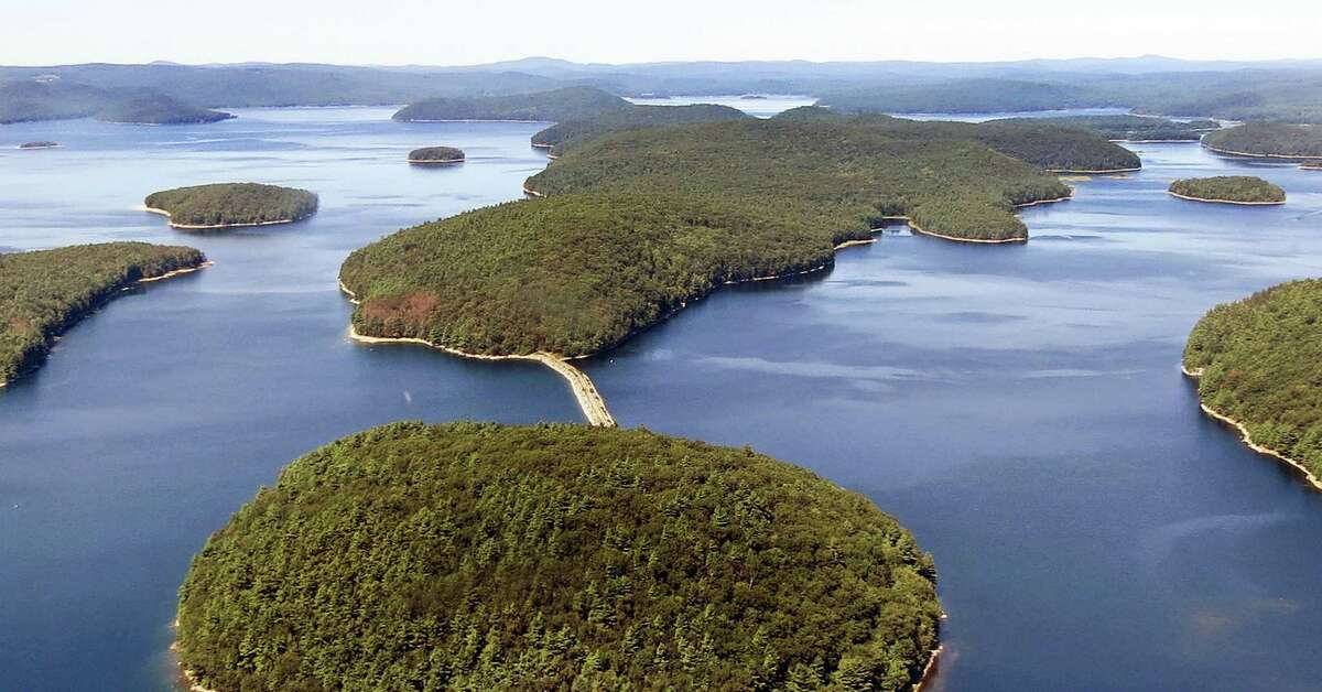 In this September 2013 aerial file photo provided by the Massachusetts Department of Conservation and Recreation, a dirt and stone road leads to Mount Zion Island, at rear, at the Quabbin Reservoir in Petersham, Mass. A plan by the state to start a colony of venomous timber rattlesnakes on the off-limits island in the state’s largest drinking water supply came under fire, and became one of New England’s odd stories in 2016.