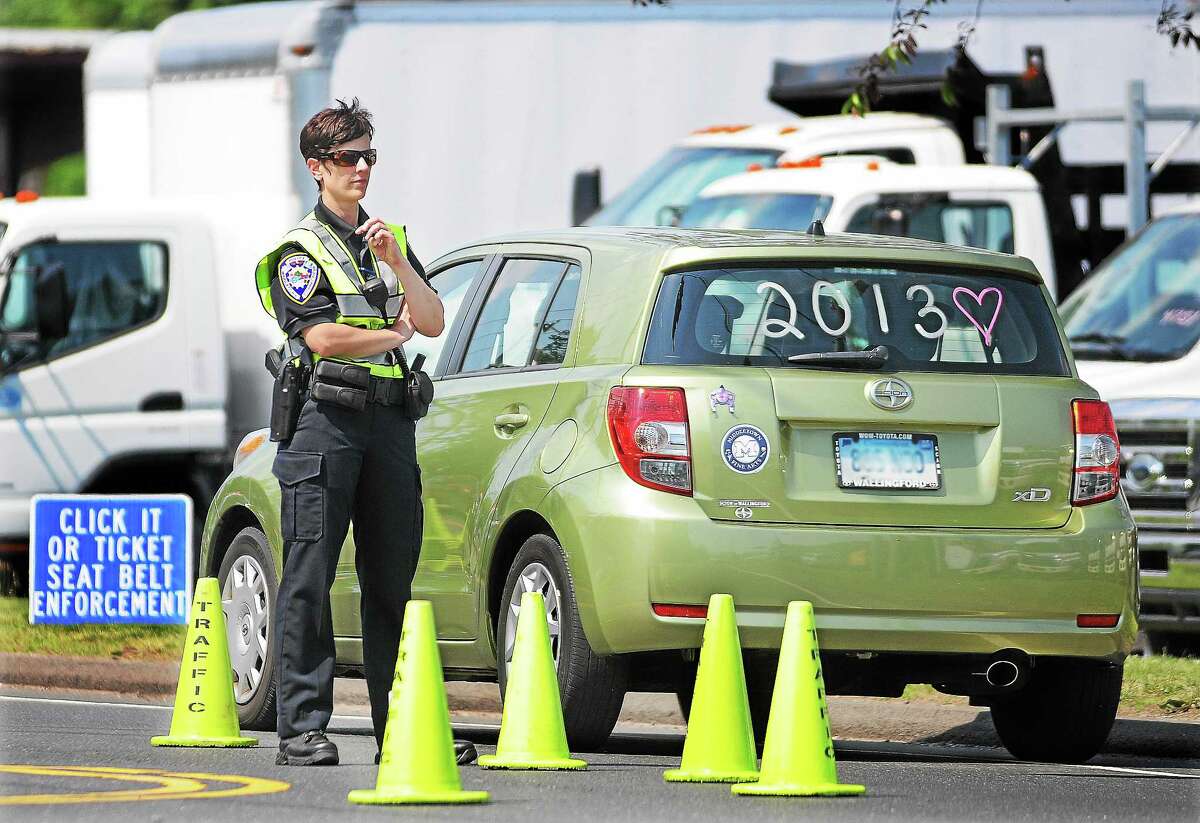 A police officer checks motorists driving without seatbelts during a recent Click It or Ticket enforcement campaign.