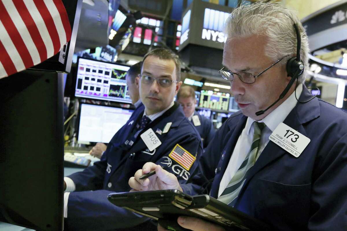 Trader Frank O’Connell, right, works on the floor of the New York Stock Exchange Thursday.