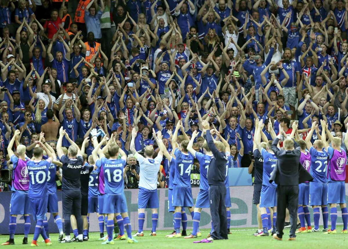Iceland players celebrate with their supporters after beating England on Monday.