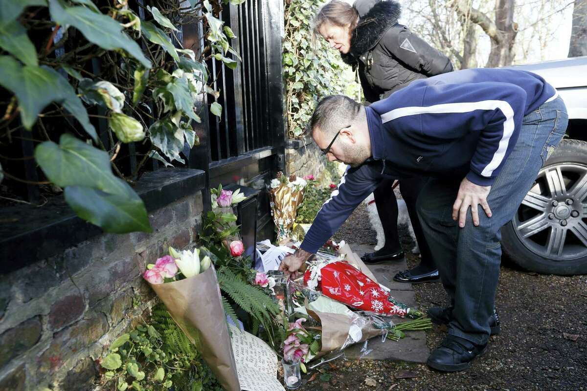 Fans leave tributes outside the home of British musician George Michael in London, Monday. George Michael, who rocketed to stardom with WHAM! and went on to enjoy a long and celebrated solo career lined with controversies, has died, his publicist said Sunday. He was 53.