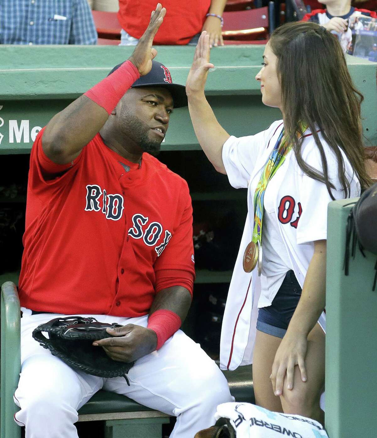 David Ortiz, left, high-fives with Aly Raisman, U.S. Olympic gold medalist in gymnastics, before she threw a ceremonial first pitch prior to Friday’s game.