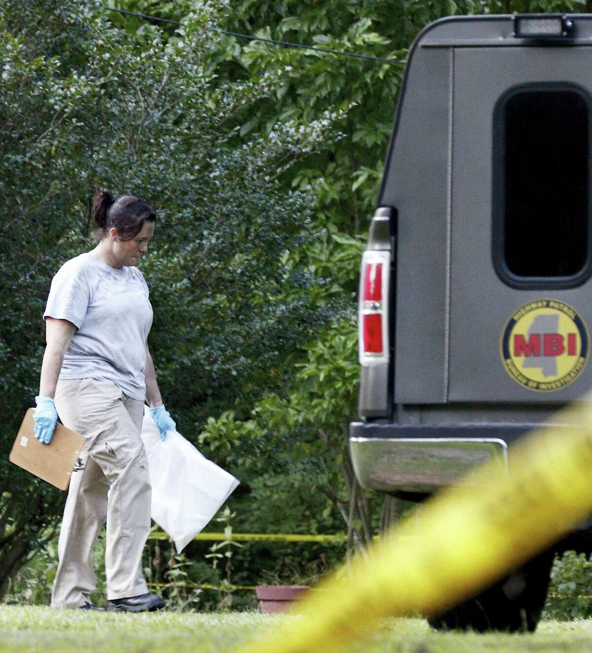 A Mississippi Bureau of Investigation agent takes a bag with evidence from the Durant, Miss., home of two slain Catholic nuns who worked as nurses at the Lexington Medical Clinic, to her vehicle, Thursday, Aug. 25, 2016. The clinic office manager and a Durant police officer discovered their bodies inside the house after both nuns did not report for work. Authorities said there were signs of a break-in and their vehicle was missing.
