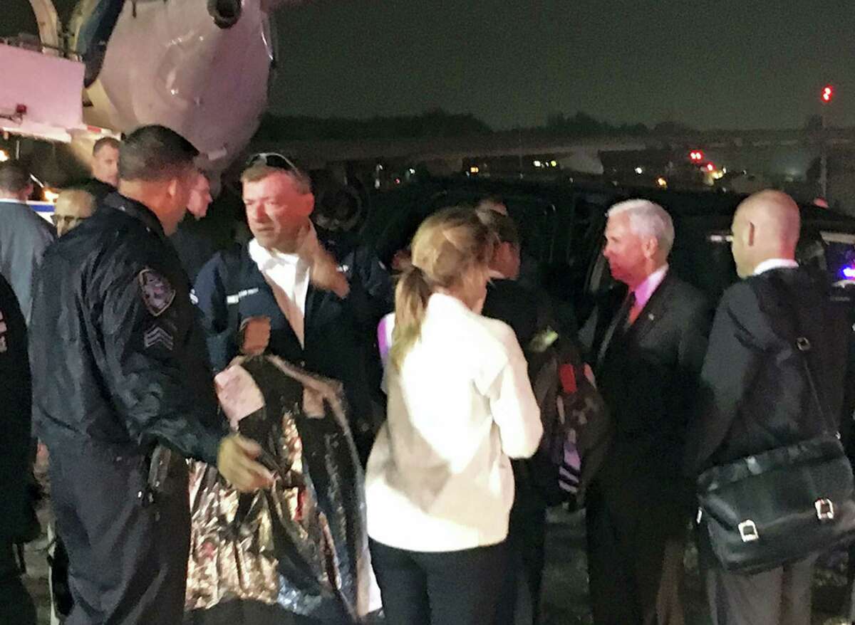 Republican vice presidential candidate Indiana Gov. Mike Pence, second from right, talks on the tarmac at New York’s LaGuardia Airport after his campaign plane slide, back left, off the runway while landing on Thursday, Oct. 27, 2016.