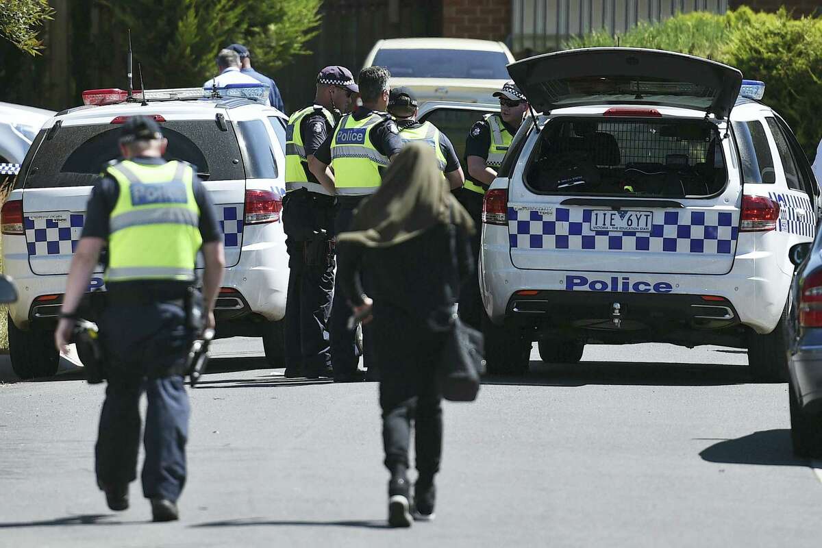 Police accompany a woman as they attend the scene where a house was raided at Meadow Heights in Melbourne, Australia, Friday, Dec. 23, 2016. Police in Australia detained five suspects who were allegedly planning a series of Christmas Day bomb attacks in the heart of the country’s second largest city, officials said Friday.