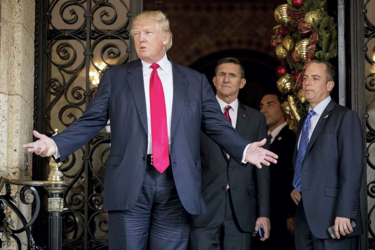 President-elect Donald Trump, left, accompanied by Trump Chief of Staff Reince Priebus, right, and Retired Gen. Michael Flynn, a senior adviser to Trump, center, speaks to members of the media at Mar-a-Lago, in Palm Beach, Fla., Wednesday, Dec. 21, 2016.