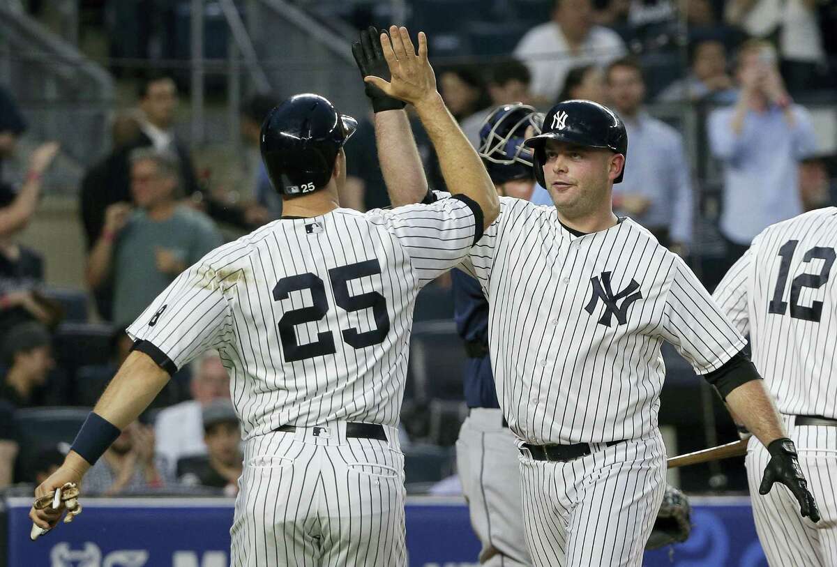 Brian McCann, right, is greeted at home plate by Mark Teixeira after hitting a two-run home run in the second inning.