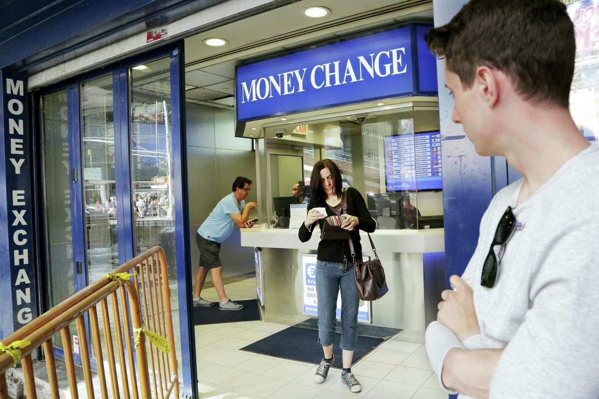 Claire Hunt, center, of Reading, England, changes pounds for dollars, Friday, June 24, 2016, at a money exchange in New York. Britain voted to leave the European Union after a bitterly divisive referendum campaign, toppling the government Friday, sending global markets plunging and shattering the stability of a project in continental unity designed half a century ago to prevent World War III. “I think the exchange went down about eight percent (from yesterday),” said Hunt, who is vacationing with her son, Jacob Wood, right. “It’s scary. I don’t know what we are going home to.”