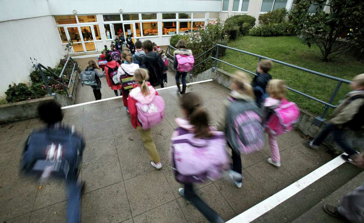 In this Oct. 5, 2012, file photo, students enter school of La Ronce in Ville d’Avray, west of Paris. France’s government has unveiled Wednesday Aug. 24, 2016, a plan to teach children how to react in case of an attack at school. Every school will have to organize three security drills per year, including one based on the scenario of an attack with at least one assailant inside the building.