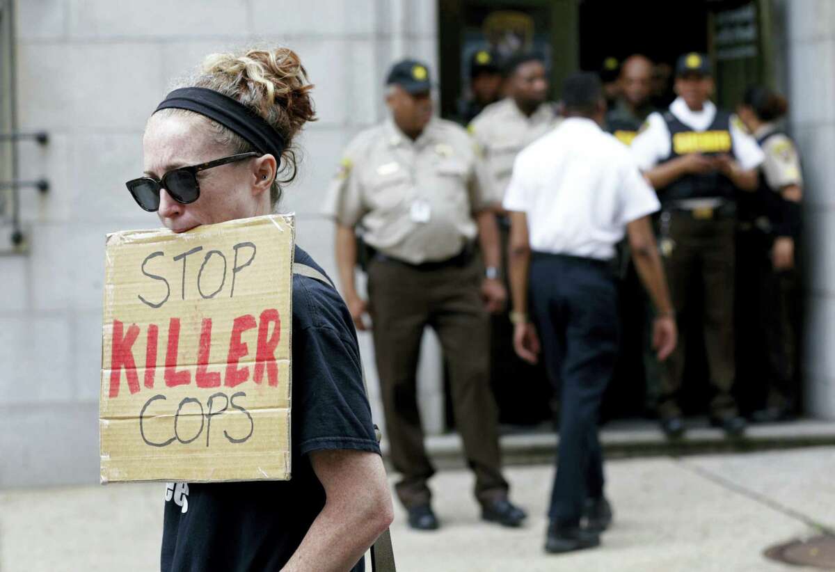A protester displays a sign outside a courthouse after Officer Caesar Goodson, one of six Baltimore city police officers charged in connection to the death of Freddie Gray, was acquitted of all charges in his trial in Baltimore, Thursday, June 23, 2016.