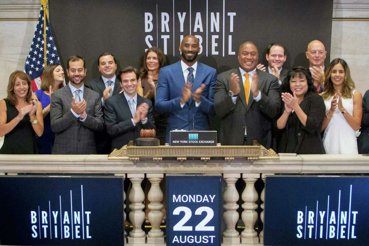 In this Monday photo provided by the New York Stock Exchange, retired NBA star Kobe Bryant, center, rings the opening bell with executives and guests of Bryant Stibel, at the NYSE in New York.