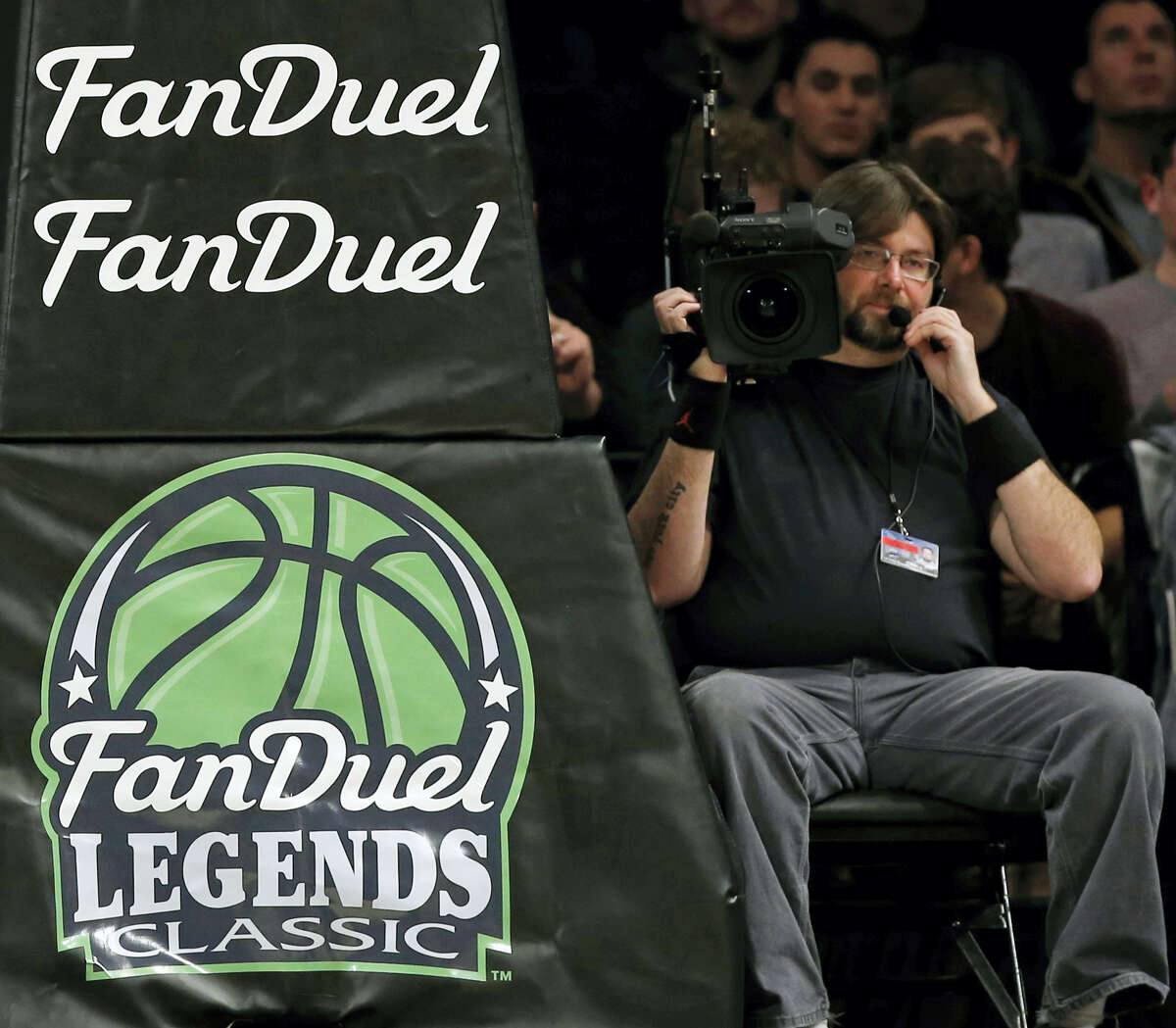 In this Nov. 24, 2015 photo, FanDuel advertising covers the post at an NCAA college basketball matchup in the FanDuel Legends Classic consolation game, at the Barclays Center in New York.