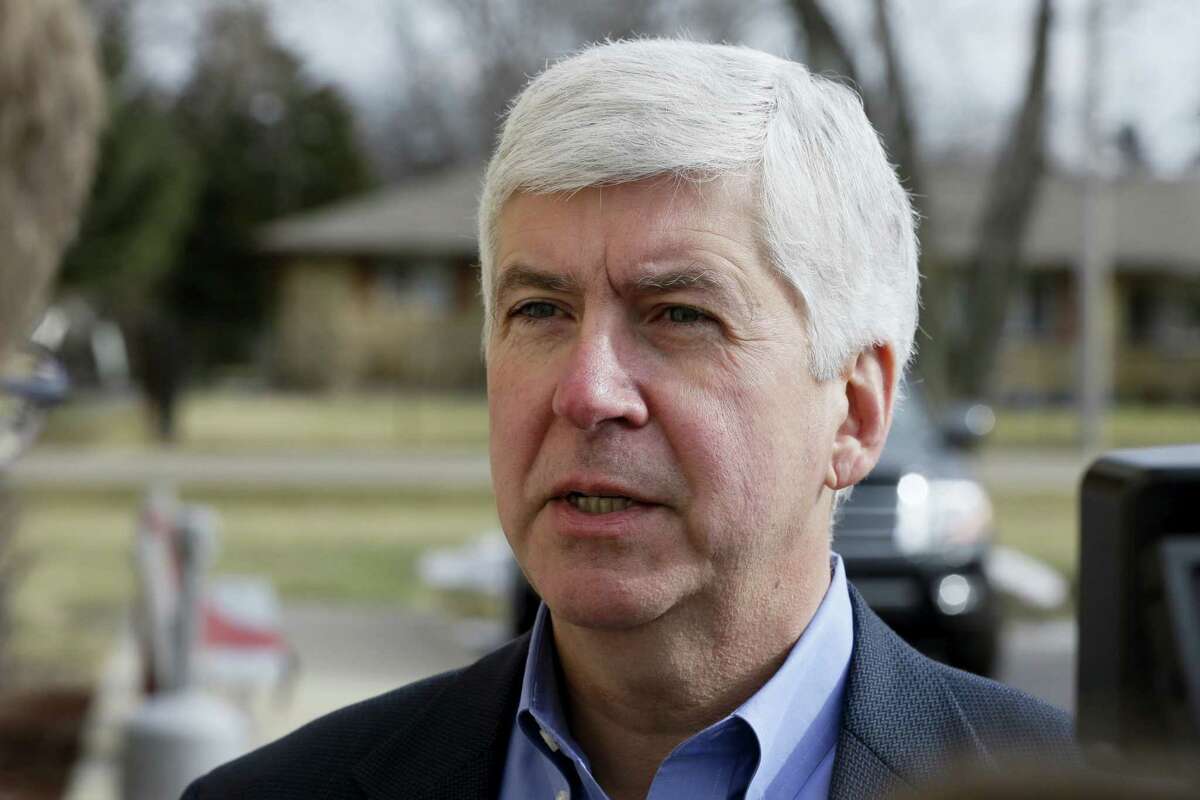 In this Friday, Feb. 5, 2016 photo, Michigan Gov. Rick Snyder is interviewed after visited a church that’s distributing water and filters to its predominantly Latino parishioners in Flint, Mich. Snyder will propose spending $195 million more to address Flint’s water crisis and another $165 million updating infrastructure across the state in response to lead contamination overwhelming the city.