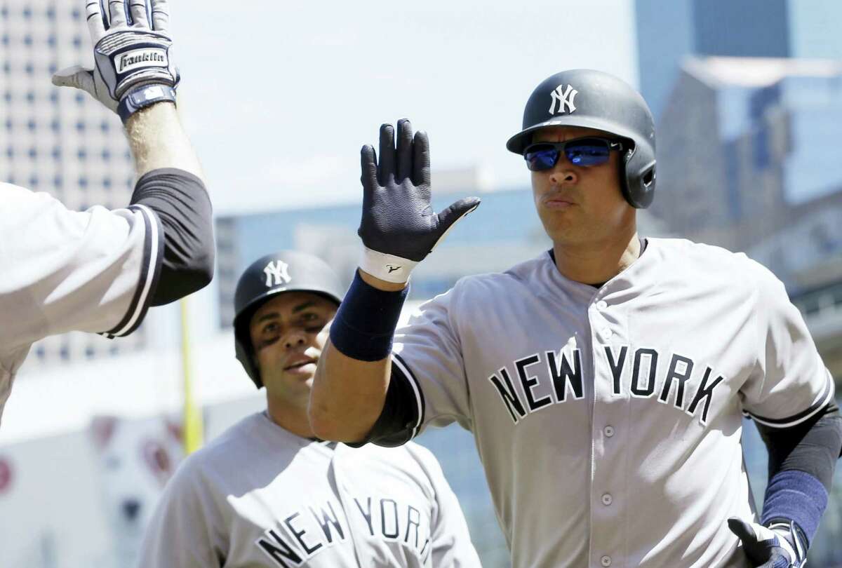 Alex Rodriguez, right, gets congratulations following his two-run home run in the seventh inning on Sunday.