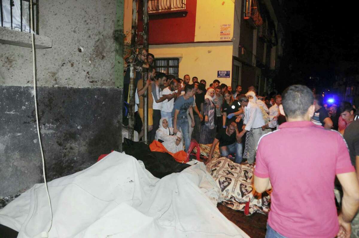 People react after an explosion in Gaziantep, southeastern Turkey, early Sunday, Aug. 21, 2016. Gaziantep Province Gov. Ali Yerlikaya said the deadly blast, during a wedding near the border with Syria, was a terror attack.