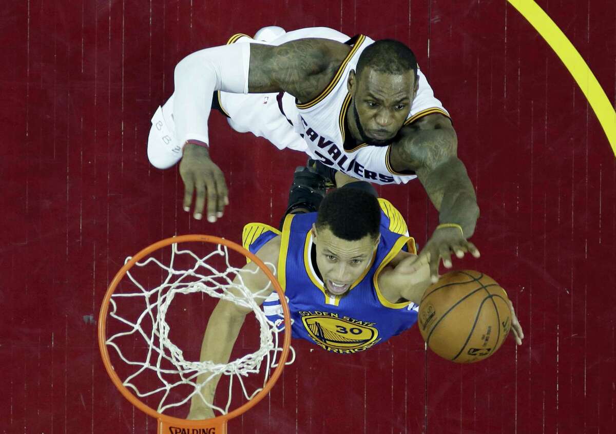 The Warriors’ Stephen Curry, bottom, drives to the basket against the Cavaliers’ LeBron James during Game 6 of the NBA Finals on Thursday. The two will face off in a rare Game 7 tonight in Oakland, Calif.