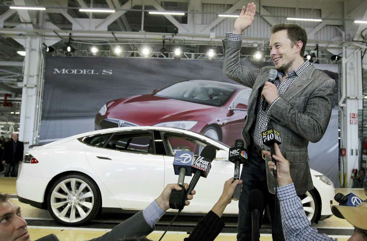 In this June 22, 2012 photo, Tesla CEO Elon Musk waves during a rally at the Tesla factory in Fremont, Calif.