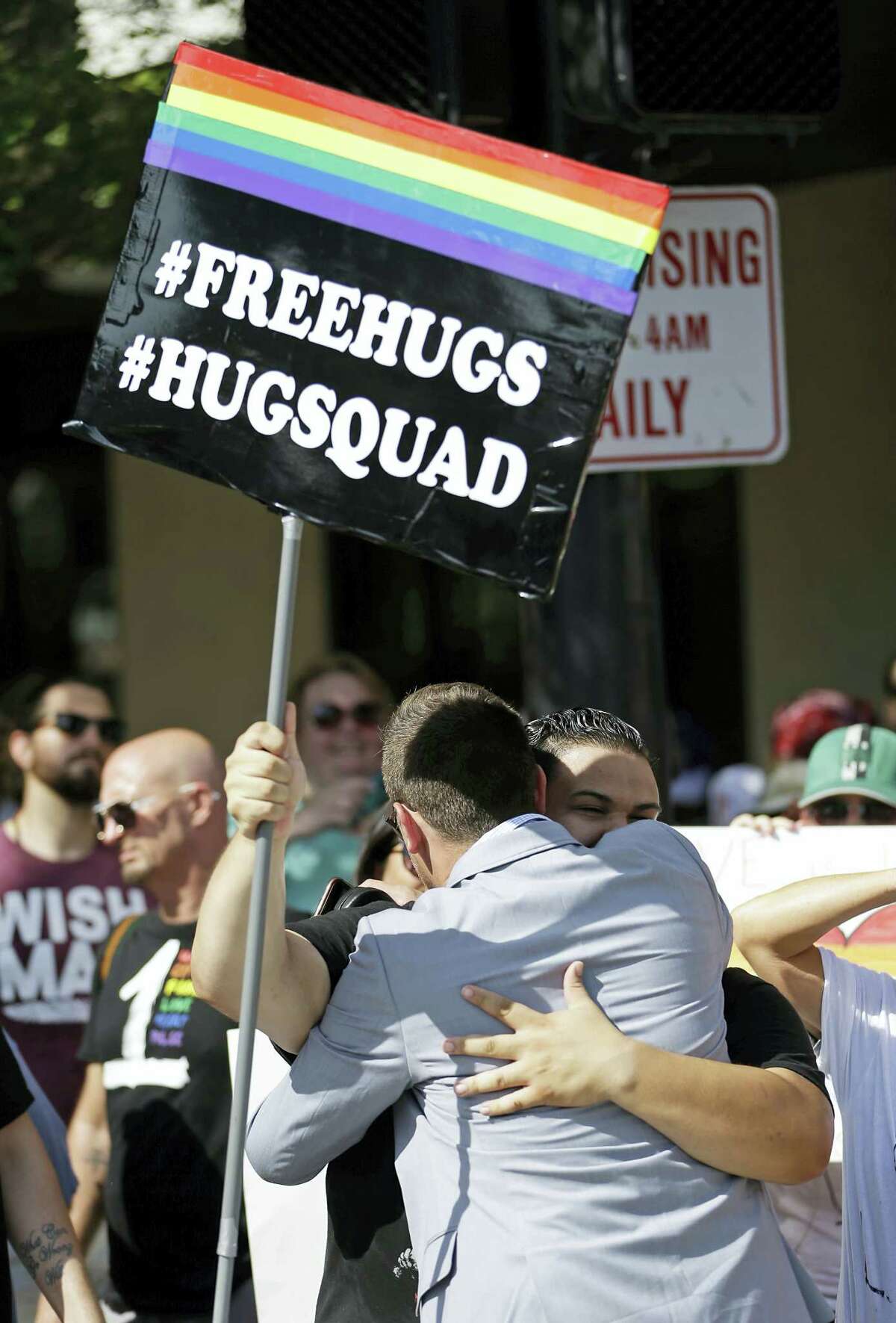 Counter demonstrators hug during a rally to show support and solidarity near the funeral service for Christopher Andrew Leinonen, one of the victims of the Pulse nightclub mass shooting, outside the Cathedral Church of St. Luke, Saturday, June 18, 2016, in Orlando, Fla.