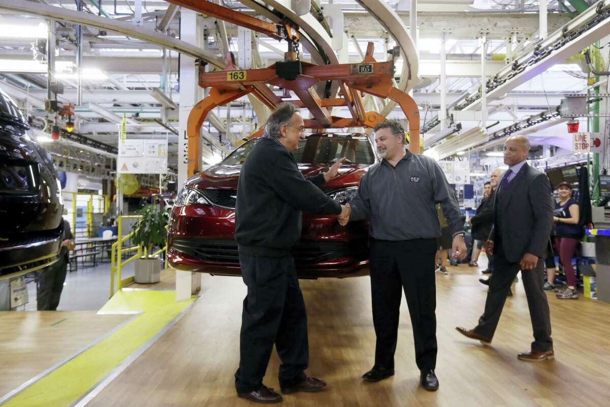 Fiat Chrysler Automobiles Chairman and CEO Sergio Marchionne, left, shakes hands with Dino Chiodo, president of Unifor Local 444, in front of a 2017 Pacifica minivan on the Windsor Assembly Plant line, in Windsor, Ontario. Fiat Chrysler and Google are working together to more than double the size of Google’s self-driving vehicle fleet by adding 100 Chrysler Pacifica minivans.