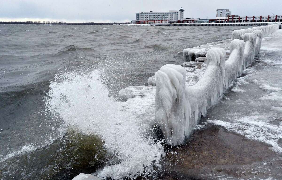 Waves crash along frozen abutments and fencing Thursday, Dec. 15, 2016 on Presque Isle Bay in Erie, Pa. Much of the northern Mid-Atlantic and Northeast will stay cold for the next couple of days as the arctic air remains stuck over the northern Appalachians, the National Weather Service said.