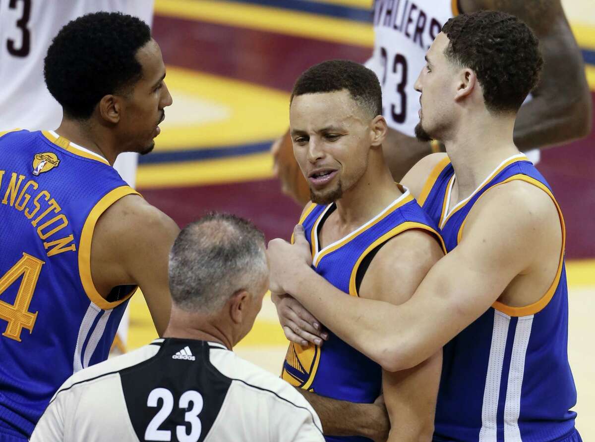 Golden State Warriors guard Stephen Curry is held back from referee Jason Phillips by Shaun Livingston, left, and Klay Thompson, right, while reacting to being called for his sixth foul in Game 6 on Thursday.