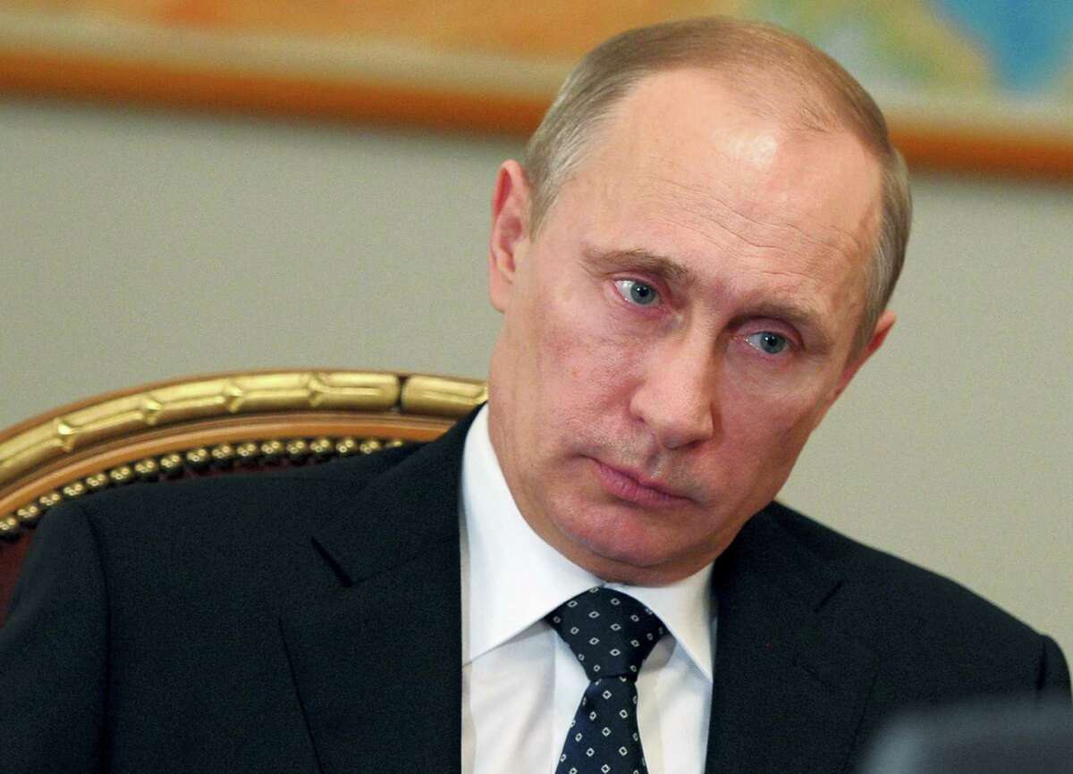 Russian President Vladimir Putin listens during his working meetings at the Novo-Ogaryovo residence outside Moscow, Russia in 2014.