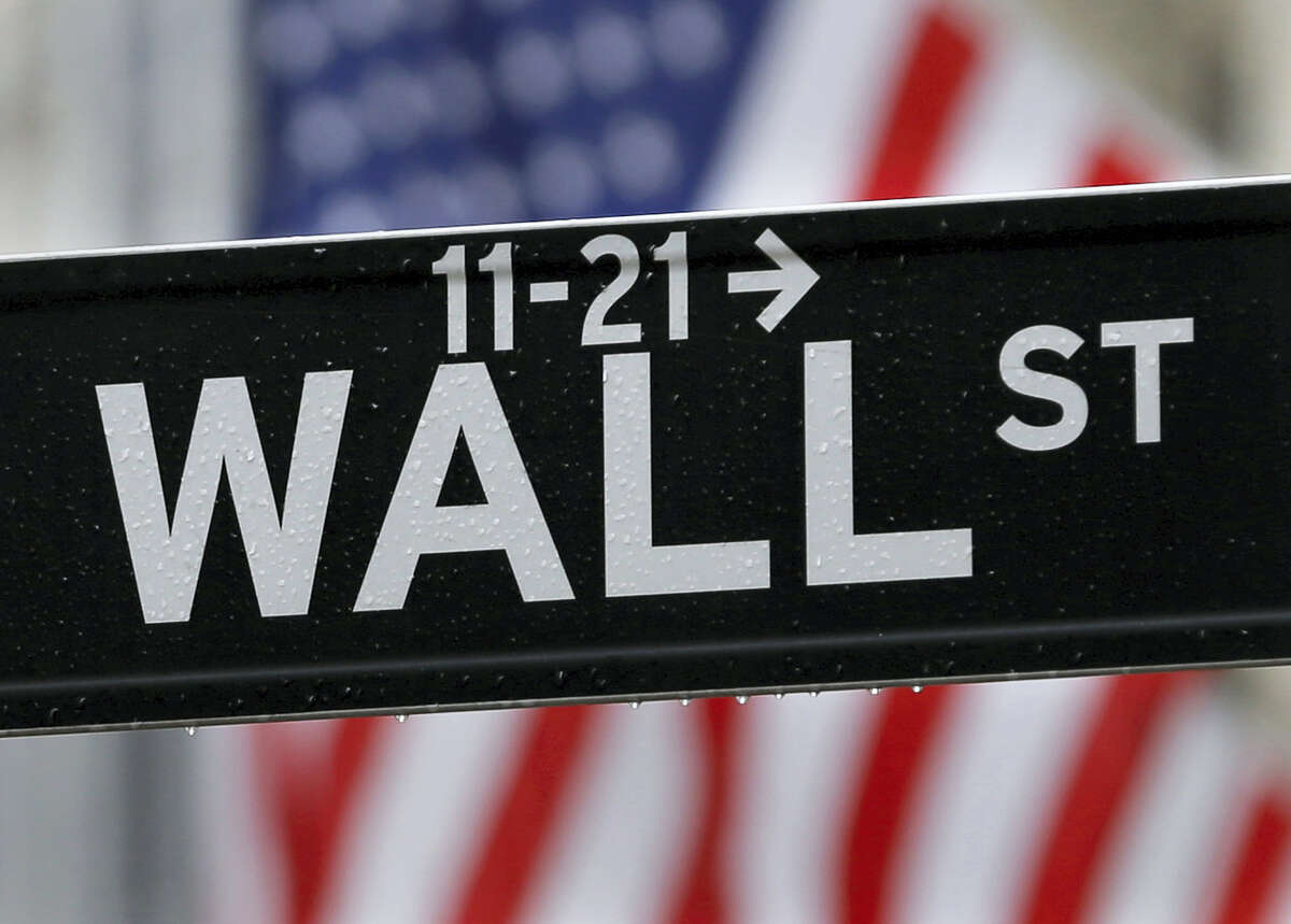 This July 9, 2015 photo shows a Wall Street sign near the New York Stock Exchange in New York. World stock markets turned lower on Friday, Aug. 19, 2016 as investors speculated whether the U.S. Federal Reserve will raise interest rates in coming months.