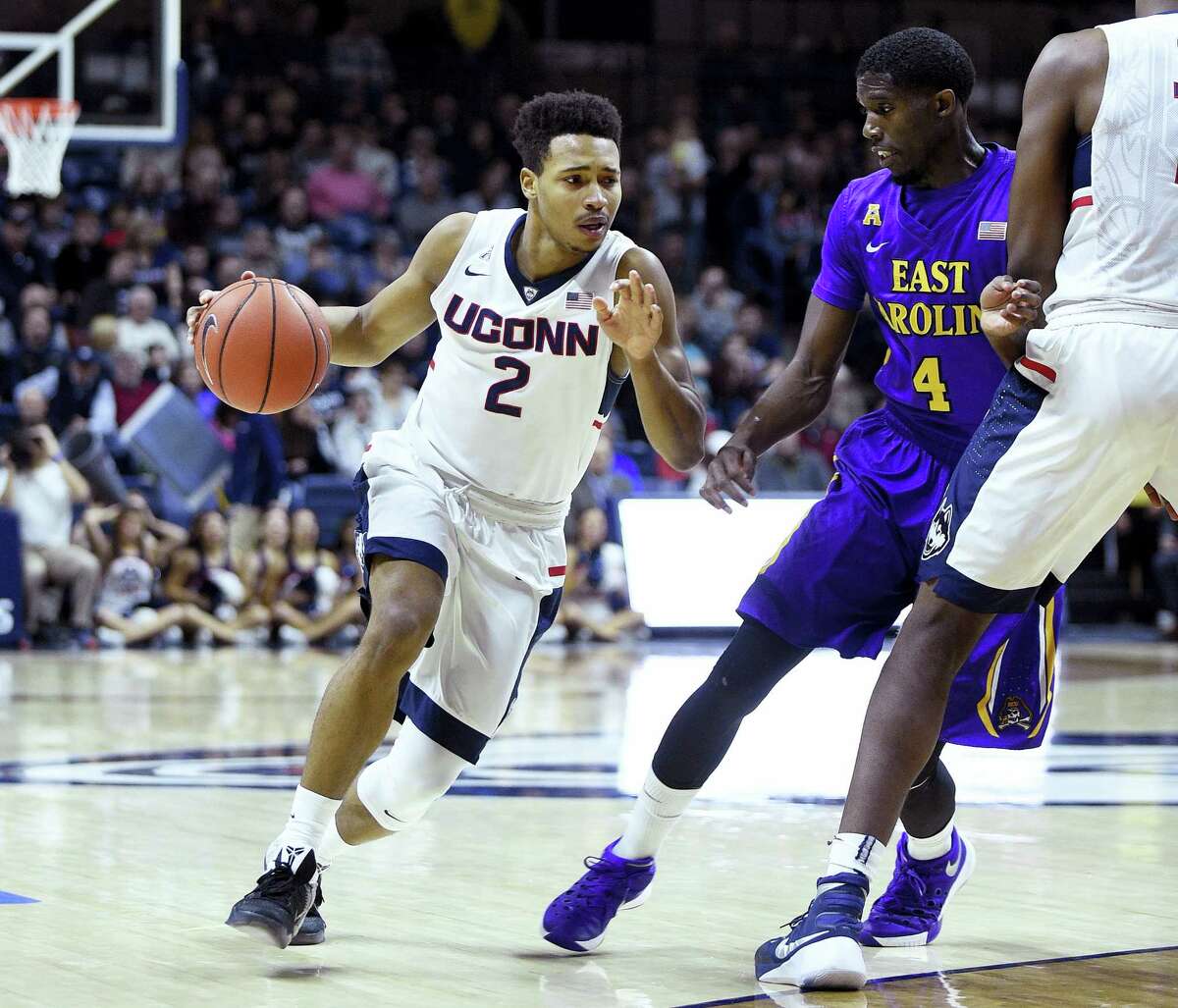 Connecticut's Jalen Adams (2) drives past East Carolina's Prince Williams (4) during the first half of an NCAA college basketball game in Storrs, Conn., on Sunday, Feb. 7, 2016. (AP Photo/Fred Beckham)