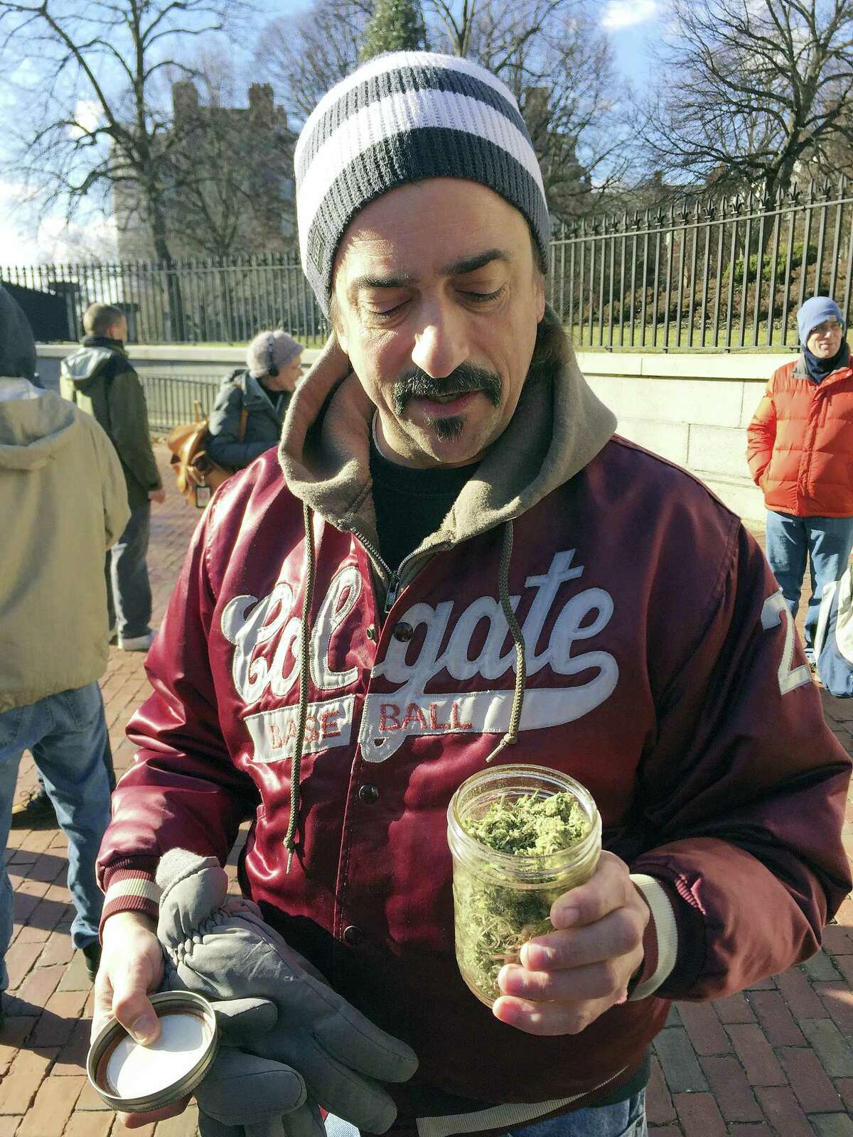 Keith Saunders, a marijuana activist from Scituate, Mass., holds a jar that he says contains just under an ounce of pot, now legal in Massachusetts. Advocates gathered in front of the Massachusetts Statehouse Thursday to celebrate the voter-approved law legalizing the recreational use of marijuana that took effect at midnight Thursday.