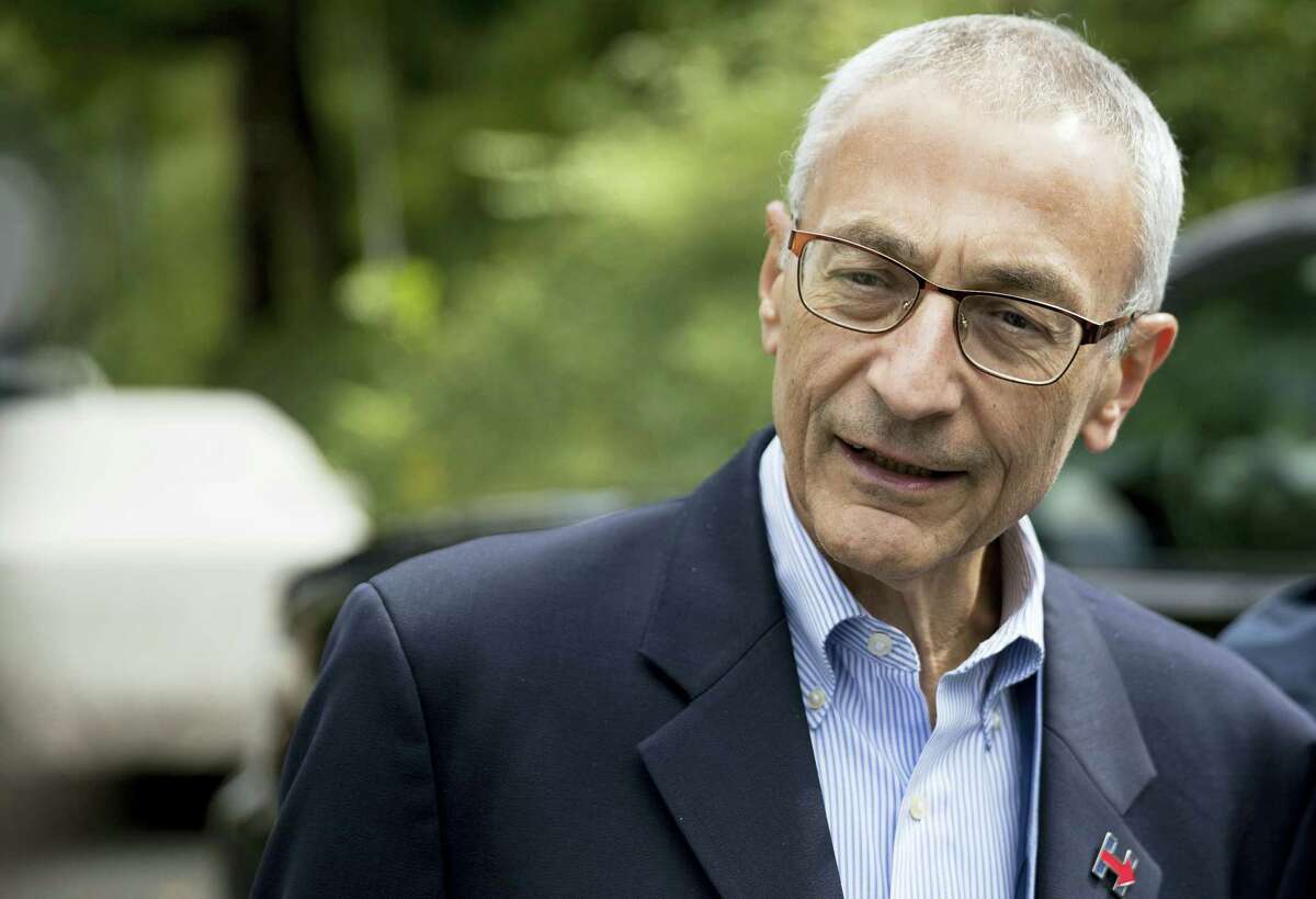 In this photo taken Oct. 5, 2016, file photo, Hillary Clinton’s campaign manager John Podesta speaks to members of the media outside Democratic presidential candidate Hillary Clinton’s home in Washington. Hacked emails reveal internal disagreement among top Clinton aides about her determination to hold a Clinton Foundation summit in Morocco that later drew attention over its reliance on large donations from foreign governments.