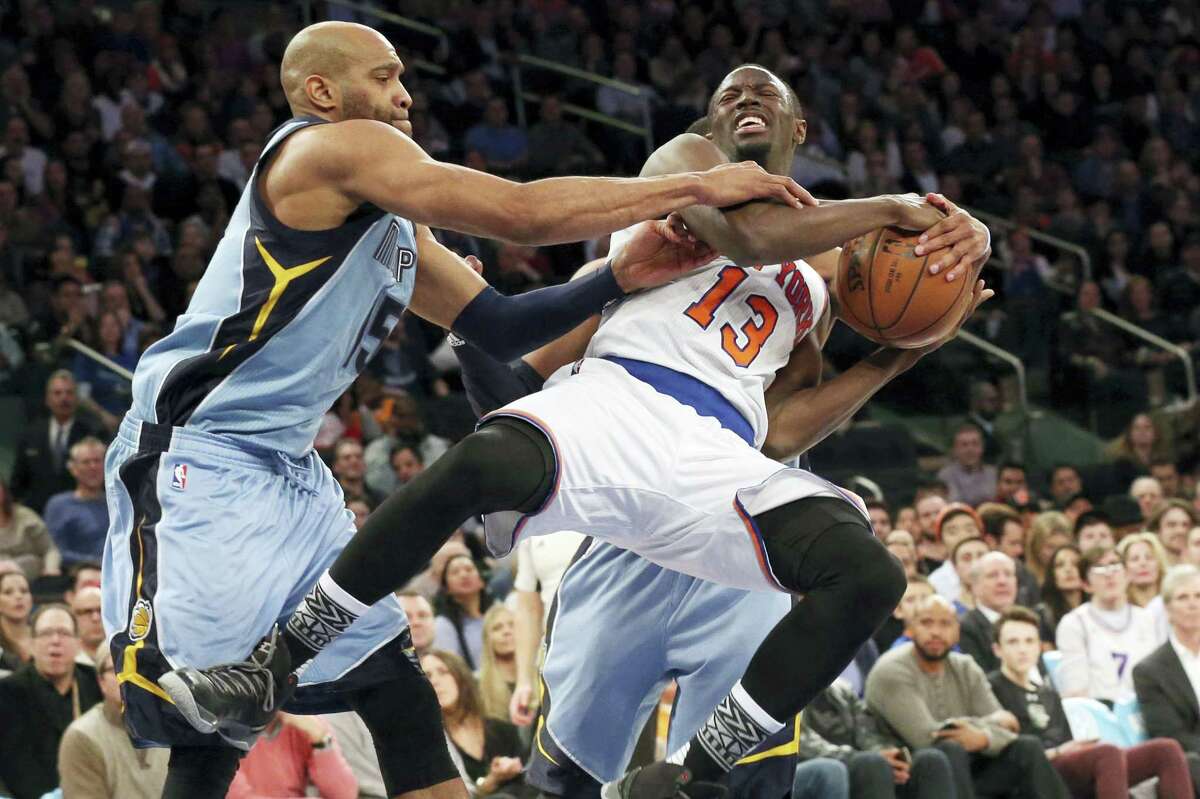 Grizzlies guard Vince Carter, left, and guard Mike Conley, in background, stop the Knicks’ Jerian Grant from going to the basket during the second half on Friday.
