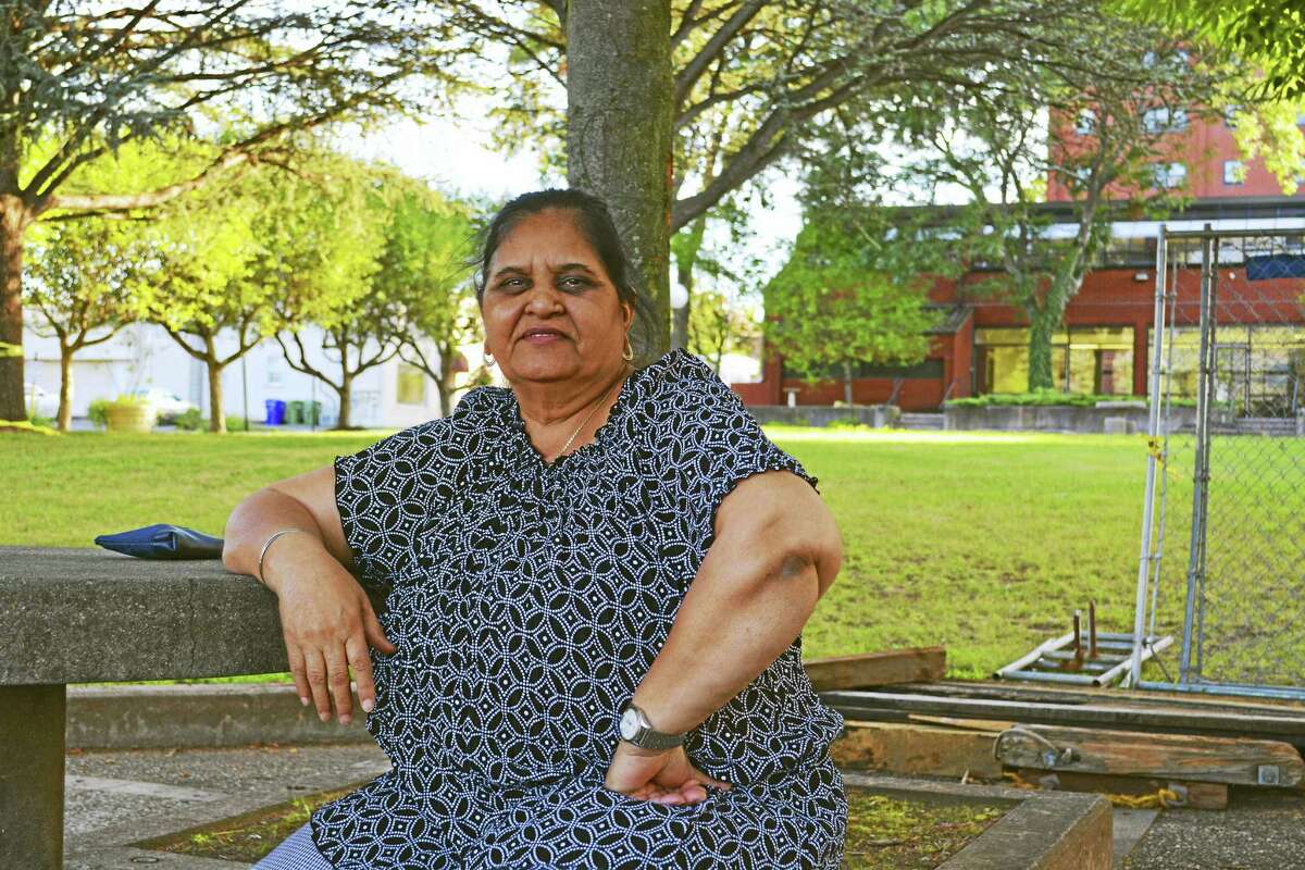 Krishna Devi enjoys the breeze and green open space as evening falls at Spear Park recently along Main Street in Middletown. The fountain and sculptures have been removed as part of $33.5 million parks bond, which is allowing work at several recreational areas and schools.