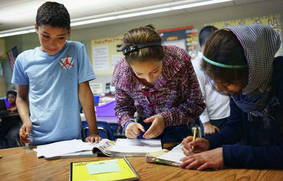 In this Oct. 4, 2016 photo, Abdulhamid Ashehneh, 12, works on English language exercises with fellow students in a class filled with refugee children at Cajon Valley Middle School in El Cajon, Calif. According to the U.S. State Department, nearly 80 percent of the more than 11,000 Syrian arrivals over the past year were children. Many of those children are enrolling in public schools around the country, including Chicago; Austin, Texas; New Haven, Connecticut; and El Cajon, which received 76 new Syrian students the first week of school.
