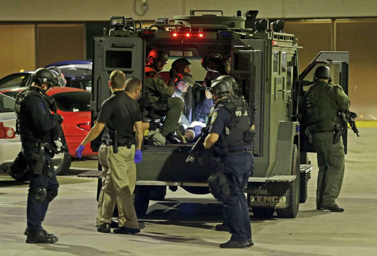 Armed police officers transport an injured man in an armored vehicle to a hospital Milwaukee on Aug. 14, 2016. Shots rang out during unrest after a police shooting that killed a man Saturday.