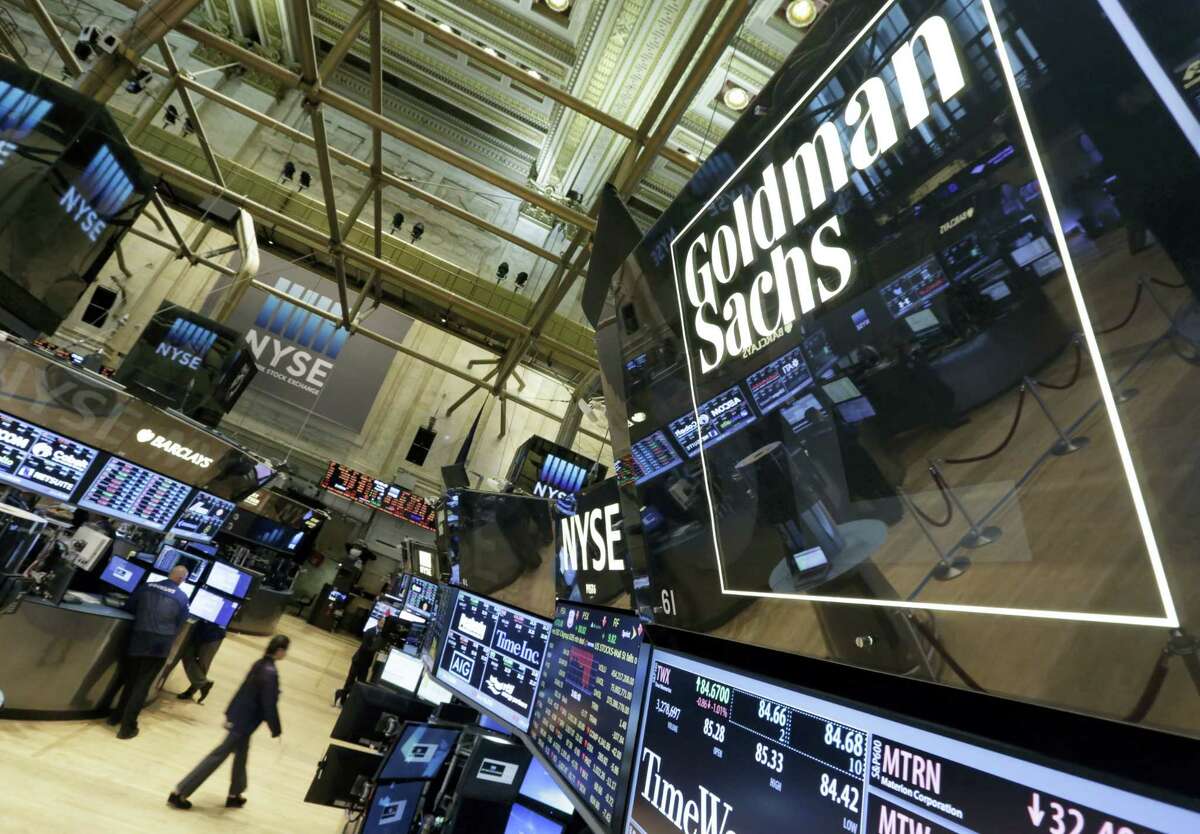 In this Aug. 15, 2014 photo, a lighted sign marks the Goldman Sachs trading post on the floor of the New York Stock Exchange.