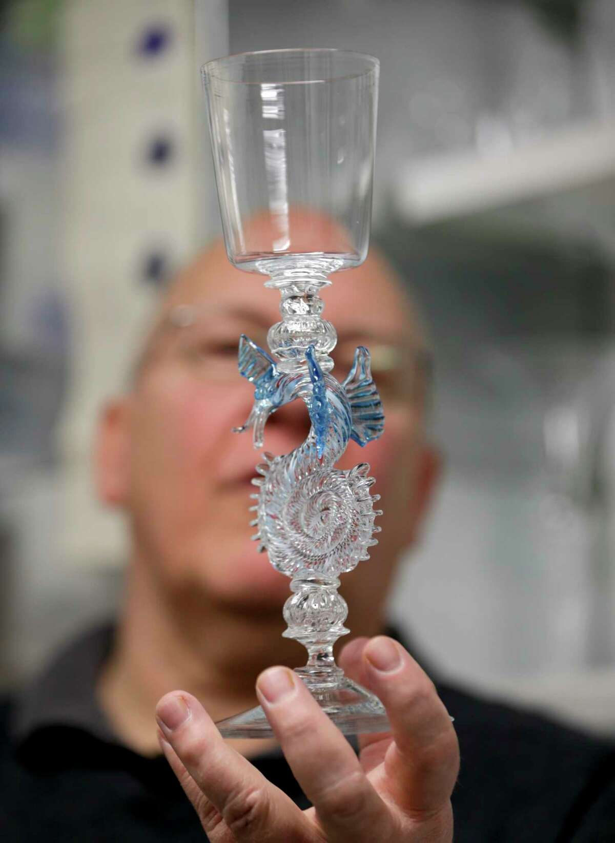 In this Friday, Jan. 22, 2016 photo, glassblower William Gudenrath holds a dragon-stem goblet at the Corning Museum of Glass in Corning, N.Y.. Gudenrath spent decades researching how Renaissance-era glassmakers produced objects that are now considered works of art.