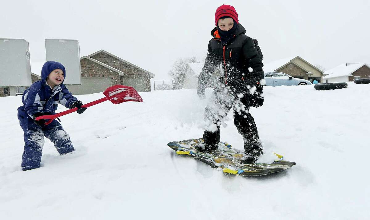 Austin Ricks, 4, left, throws snow on Brandon Grimes, 9, while they play in the snow in Asbury, Iowa, on Dec. 11, 2016. Dubuque, Iowa, received 4 inches of snow overnight, less than forecasters had expected.