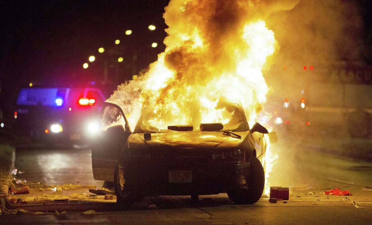 A car burns as a crowd of more than 100 people gathers following the fatal shooting of a man in Milwaukee on Aug. 13, 2016. The Milwaukee Journal Sentinel reported that officers got in their cars to leave at one point, and some in the crowd started smashing a squad car’s window, and another vehicle, pictured, was set on fire.