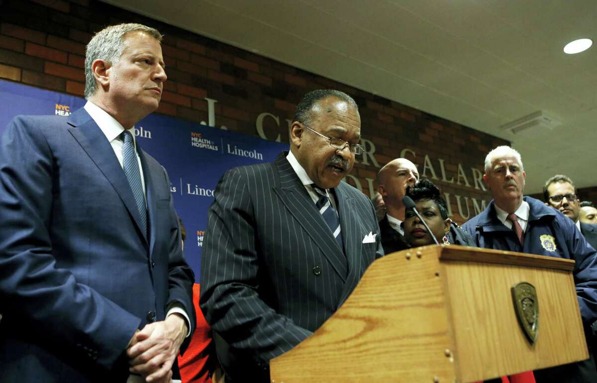 New York City Mayor Bill de Blasio listens as New York City Police First Deputy Commissioner Benjamin Tucker speaks at a hastily called press conference at Lincoln Hospital, Thursday, Feb. 4, 2016, in the Bronx borough of New York after two New York City police officers were shot in a public housing complex int he Bronx by an armed suspect who apparently turned the weapon on himself not far from wherede Blasio was delivering his state of the city address Thursday evening. New York Police Department Chief of Department James P. O’Neill, listens, far right.