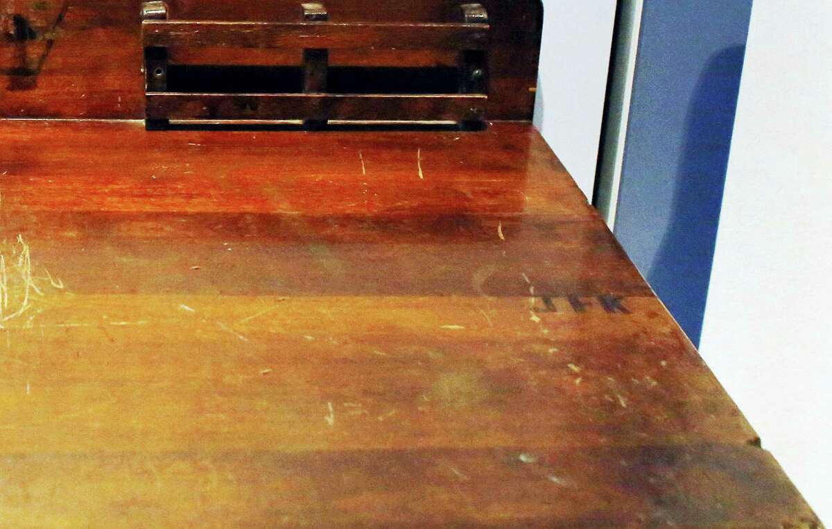 In this Nov. 5, 2015 photo, a detail shows the initials “JFK,” right, on a desk displayed in the exhibit titled “Young Jack” at the John F. Kennedy Presidential Library and Museum in Boston.