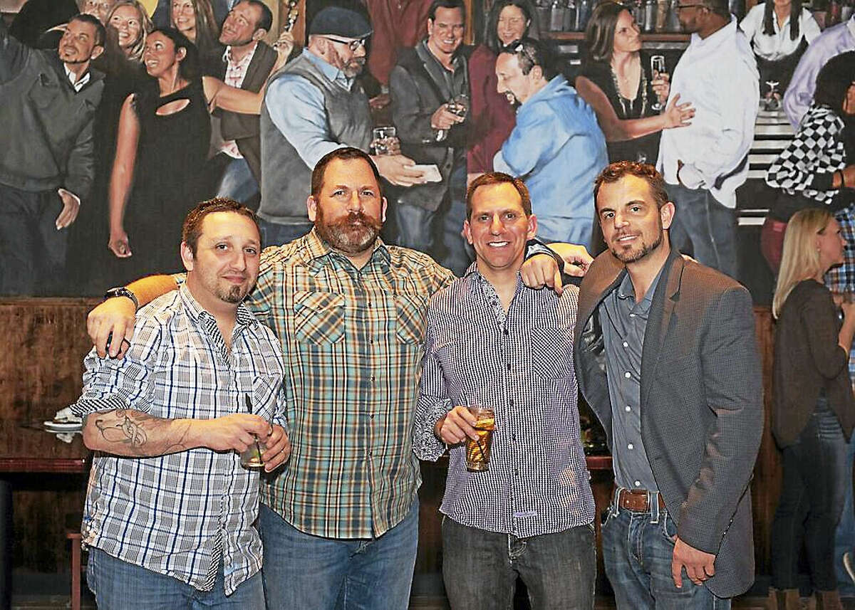The four owners of Herd restaurant are, from left, Dan “Serge” Sergi, David Shapiro, Jonathan Shapiro and Patrick Ganino. In the background is the mural Ganino painted that shows the owners, their wives and friends enjoying themselves.