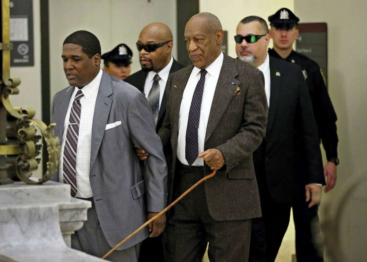 Holding onto his security team, Bill Cosby uses a cane as he returns to Courtroom A after a lunch break on Wednesday, Feb. 3, 2016, in the Montgomery County Courthouse in Norristown, Pa. The prosecutor in the sexual assault case against Cosby argued Wednesday that his predecessor had no legal authority to make a deal a decade ago that would shield the comedian from ever facing charges.