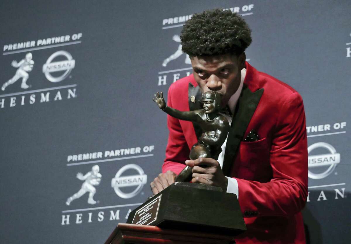 Louisville’s Lamar Jackson poses with the Heisman Trophy after winning the award on Saturday in New York.