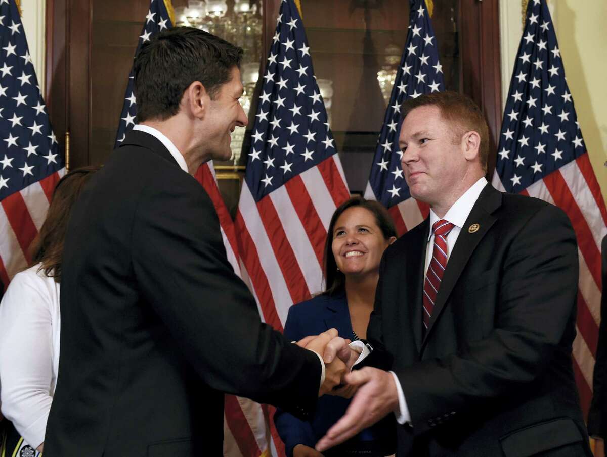 House Speaker Paul Ryan of Wis., left, shakes hands with Rep.-elect Warren Davidson, R-Ohio, right, before Davidson is officially sworn in on Capitol Hill in Washington, Thursday.
